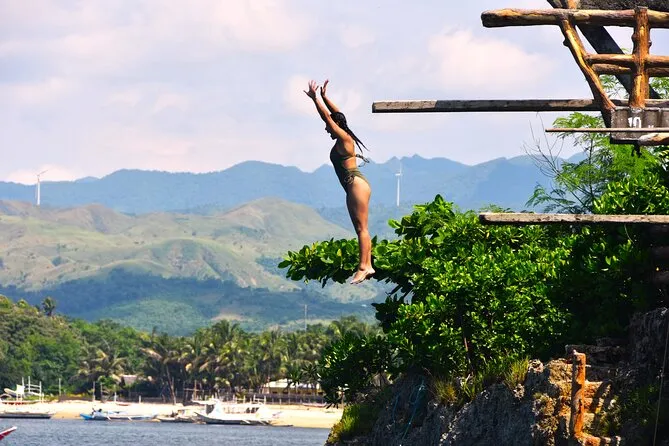 Outrigger boat anchored off a white-sand beach on a private Boracay island hopping tour package, Philippines